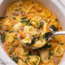 a white bowl filled with pasta and spinach