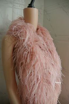 a mannequin wearing a pink feathered scarf