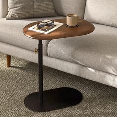 a coffee table with a magazine on it next to a gray couch and grey carpet