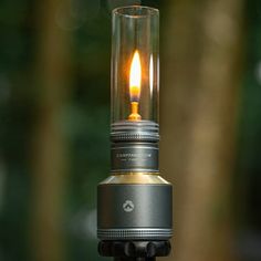 a light that is on top of a tripod in the dark with trees in the background