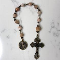 Handmade traditional Catholic single decade tenner rosary using Peach Moonstone smooth round stone beads. Antique bronze daisy bead caps on every bead with additional flower bead caps on Our Father bead. Antique bronze St. Benedict medal (Patron Saint of students) with Pardon Crucifix. Hail Mary beads are 8mm with the Our Father bead being 10mm. Designed to be used and/or displayed. Measures about 10.25" long. This rosary would make a beautiful gift for a baby shower, Baptism, First Communion, Reconciliation, Confirmation or any other special event or occasion. Comes in a beautiful black velvet pouch. I ship same or next business day. All of my rosaries are one of a kind and are my own personal creation. Photos are a part of the description-you will receive the exact rosary pictured. Pleas Adjustable Spiritual Rosary With Spacer Beads, Spiritual Round Beads Rosary For Jewelry Making, Adjustable Rosary With Polished Beads For Meditation, Adjustable Polished Beads Rosary For Meditation, Adjustable 8mm Beads Rosary For Healing, Adjustable Round Spiritual Rosary, Adjustable Spiritual Rosary, Spiritual Rosary Bracelet With Round Beads For Jewelry Making, Spiritual Beaded Rosary For Jewelry Making