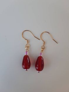 Drop length earrings featuring red glass beads with pink seed beads. Gold-coloured fittings. Drop length measurement is the whole length including the ear wire.  Pretty earrings for any occasion. Pink Bead Earrings, Red Handmade Drop Earrings, Red Czech Glass Beaded Earrings With Dangling Beads, Red Long Drop Earrings With Ear Wire, Red Beaded Czech Glass Earrings, Red Czech Glass Earrings With Dangling Beads, Handmade Red Czech Glass Beaded Earrings, Red Long Drop Earrings With Dangling Beads, Red Teardrop Beaded Dangling Earrings