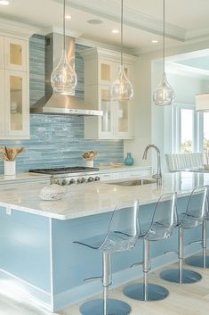 a kitchen with white cabinets and blue counter tops, four bar stools in front of the island