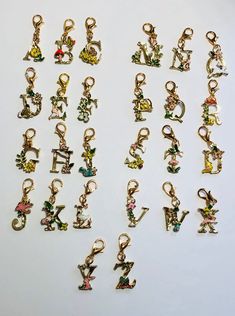 many different types of charms sitting on a table next to each other with letters and numbers in them