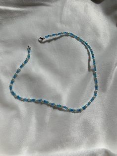 This necklace is made of blue seed beads and small pearls with a clasp. The beads are small for a cute minimalist look while still having a sophisticated and preppy look. They really fit in with the outer banks style which is so trendy at the moment! It can be styled with so many pieces to make any outfit really cute and trendy. This vsco style is so popular at the moment and this necklace is the perfect fit for that! Something that kiara from outer banks might wear! Gift for him, gift for her p Trendy Blue Choker With Colorful Beads, Trendy Blue Beaded Chain Bracelet, Trendy Blue Beaded Choker, Trendy Blue Beaded Bracelet, Blue Tiny Beads Choker For Summer, Blue Pearl Beaded Necklaces For Beach, Blue Single Strand Beaded Necklace For Summer, Summer Blue Beaded Choker, Trendy Blue Jewelry With Tiny Beads