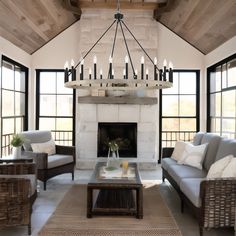 a living room with couches, chairs and a fire place in front of windows