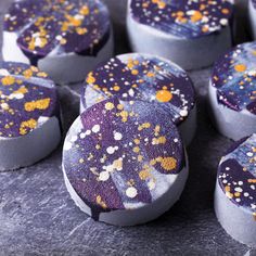 purple and gold decorated cookies sitting on top of a table