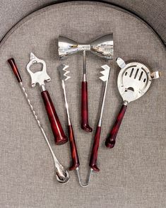 five different types of kitchen utensils arranged on a round table with silverware