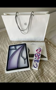 an apple ipad with its box opened and the package next to it on a bed