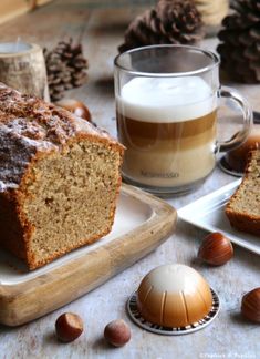 a loaf of bread sitting on top of a white plate next to a cup of coffee