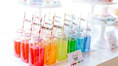 colorful drinks are lined up on a table