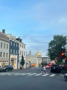 people are crossing the street in front of some buildings