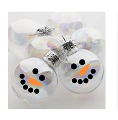 four glass ornaments with black dots and a snowman face on one ornament