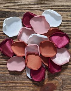 several pieces of pink and white paper on a wooden surface