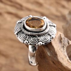 Ornate settings evoke a splendid Balinese sunflower. Crowned with faceted citrine this stunning ring is crafted by hand. Bali's Kadek Hendra works in sterling silver taking his inspiration from traditional Indonesian art. The gemstone totals 2 carats. .925 Sterling silver