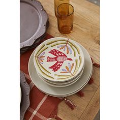 plates and glasses on a wooden table with red plaid placemats in the background