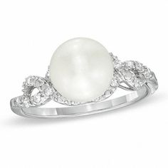 A masterpiece of design and elegance, this pearl and diamond ring will take her breath away. Expertly crafted in sleek sterling silver, this ring captivates with a stunning 8.5-9.0mm cultured freshwater pearl at its center. Ribbons of shimmering diamonds surround the center stone and create the cleverly twisting shank. Radiant with 1/10 ct. t.w. of diamonds, this ring is finished with a bright polish. Custom made to fit her ring size. Sterling silver rings cannot be resized after purchase. White Solitaire Pearl Ring, White Solitaire Pearl Ring, Round Cut, Classic White Pearl Ring With Diamond Accents, Formal White Pearl Ring With Center Stone, Timeless White Gold Pearl Ring With Center Stone, White Diamond Ring With Diamond Accents, White Pearl Rings With Diamond Accents, Timeless White Gold Pearl Ring With Diamond Accents, White Pearl Ring With Center Stone For Fine Jewelry