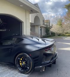 a black sports car parked in front of a garage