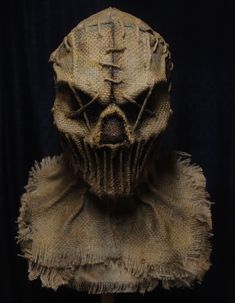 a creepy looking mask is on display in front of a black background