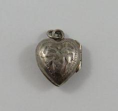 "This is a vintage mechanical \"Small Heart Shaped Locket\" sterling silver charm for a charm bracelet or pendant for necklace.  It weighs 1.65 grams and measures 1/2\" x 5/8\", marked \"STER\" All charms come with a split ring to attach to a bracelet. We have hundreds of charms in stock. If you don't see what you are looking for in our shop please contact us as it is likely we have it. Inventory #13155" Victorian Heart Charms Jewelry, Victorian Heart-shaped Charms Jewelry, Vintage Keepsake Charms Jewelry, Vintage White Gold Jewelry With Heart Charm, Vintage Keepsake Jewelry With Charms, Vintage Heart Charm Round Pendant Jewelry, Vintage Nickel-free Heart Pendant Jewelry, Vintage Sterling Silver Charms For Gifts, Vintage Nickel Free Heart Jewelry