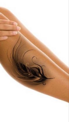 a woman's arm with a feather tattoo on it