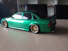 a toy car that is green with gold rims