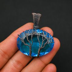 a person holding a blue pendant in their hand