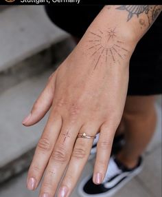 a person's hand with a tattoo on it and a ring in the middle