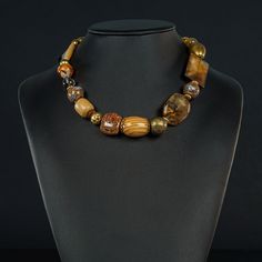 This 19" multi camel/gold tone necklace will always please you with its varied and unusual bead blend: Wood, Agate, Shell, Brass, Ceramic and gold-filled. Just for your interest,  the Shell rectangle is 24x35mm. The round gold tone spring clasp is 18mm wide Adjustable Bronze Jewelry With Polished Beads, Bronze Jewelry With Large Beads, Bronze Polished Round Bead Jewelry, Bronze Beaded Necklaces With Large Beads For Gift, Bronze Jewelry With Polished Round Beads, Unique Adjustable Amber Beaded Necklace, Bronze Spiritual Jewelry With Polished Beads, Bronze Necklaces With Large Round Beads, Artisan Bronze Jewelry With Polished Beads