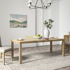 a dining table with two chairs and a vase on the table in front of it