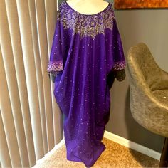 This Stunning Purple Kaftan-Style Dress Is A Must-Have For Any Formal Or Holy Communion Event. The Dress Features A Round Neckline, Pullover Closure, And 3/4 Kimono Sleeves. The Lightweight, Wrinkle-Resistant Cotton Fabric Is Perfect For Summer, Fall, Or Spring Seasons. The Dress Is Embellished With Intricate Embroidery, Rhinestone Accents, And Sequin Details, Giving It A Unique And Elegant Look. It Is Available In One Size, Making It Perfect For Women Of All Shapes And Sizes. The Collarless Des Bollywood Embellished Embroidered Dress For Eid, Traditional Embellished Floor-length Dress, Traditional Embellished Silk Embroidered Dress, Embellished Maxi Dress For Party And Festivals, Embellished Bollywood Tunic Kaftan, Bollywood Style Embellished Tunic Kaftan, Bollywood Style Embroidered Tunic Dress, Bollywood Tunic Dress For Eid, Embellished Kaftan For Party And Festivals