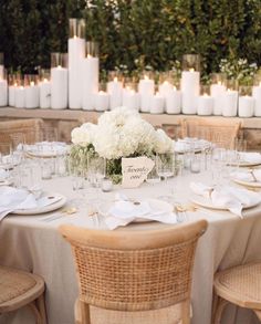 the table is set with white flowers and candles