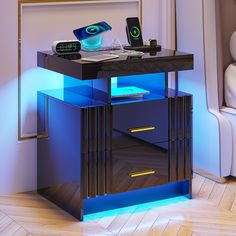 a night stand with two drawers and an alarm clock on top, lit up by blue light