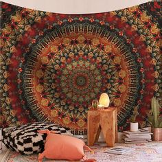 a large tapestry hanging on the wall next to a small table with a lamp in it