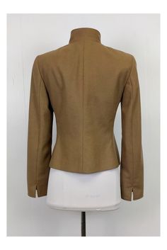 This tailored blazer is made in a rich tan color. Designed with a stand up collar and dark gold rounded buttons. It can be paired with fitted skirts or trousers. Size 6 60% wool, 40% angora Made in Switzerland Button down Dark gold buttons Stand Up collar Zip Up pockets Bust 36" Waist 32.5" Shoulder to hem 21.5" Fitted Brown Blazer With Hidden Button Closure, Brown Fitted Blazer With Concealed Placket, Fitted Brown Blazer With Concealed Placket, Fitted Blazer With Stand Collar, Fitted Brown Blazer For Work, Beige Stand Collar Blazer, Fitted Stand Collar Blazer For Work, Fitted Blazer With Stand Collar For Work, Tailored Chic Blazer With Stand Collar