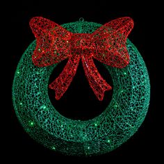 a lighted christmas wreath with a red bow on it's front and green mesh around the wreath