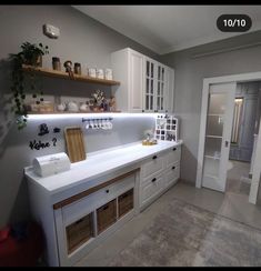 a kitchen with lots of white cabinets and drawers