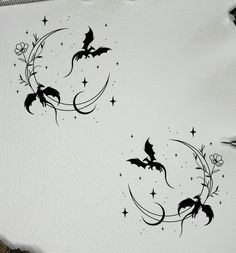 two bats flying over the moon with stars and flowers on it's back side