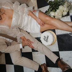 a man and woman laying on the floor next to each other with their wedding cake in front of them