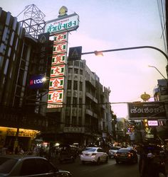 a busy city street filled with lots of traffic and tall buildings covered in neon signs