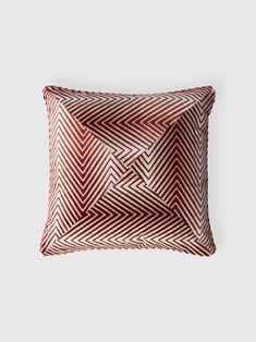 a red and white pillow on a gray background