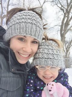 a woman and child wearing knitted hats in the snow