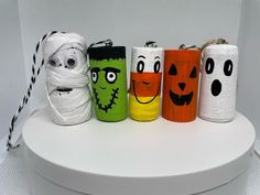 four different colored toilet rolls with faces on them