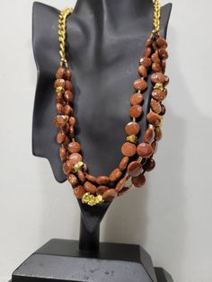 "Multistrand goldstone glass bead and gold nugget layered necklace. Three strands of glass beads (faceted and smooth) with a gold finish curb link chain tying them together. Color is a gold dusted rich dark copper. Goldstone is a type of glittering glass made in a low-oxygen reducing atmosphere. ●Length: 22\" ●Linda's Designers Group features a collection of unique china, luxury estate sale handbags, vintage statement jewelry and handmade 'one of a kind' jewelry. We will gladly provide additiona Brown Faceted Beads Jewelry For Party, Brown Gold Beads Jewelry For Party, Gold Multi-strand Jewelry With Polished Beads, Adjustable Gold Layered Necklace With Round Beads, Gold Polished Double Strand Beads, Gold Double Strand Polished Beads Jewelry, Gold Double Strand Polished Beads, Gold Layered Necklace With Round Beads, Brown Czech Glass Jewelry With Beaded Chain