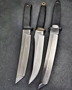 three knives sitting next to each other on a table