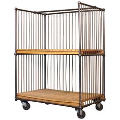 a metal cage with wooden shelves on wheels