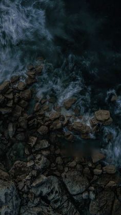 an aerial view of rocks and water in the ocean