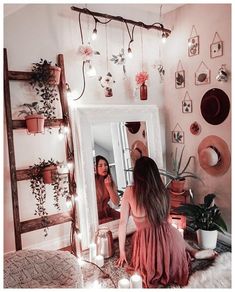 a woman sitting in front of a mirror with candles on the floor next to her