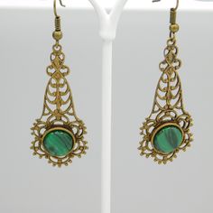 Long filigree earrings are a soft aged brass and have a green black glass stone at the bottom. These are so pretty and lightweight. The contrast of the brass and green is really nice. The earwires were missing so I did replace them. They are unmarked and in excellent condition. The drops alone measure 1 3/4 inch and from the top of the earwire to the bottom of the drop they are 2 1/4 inch. The kind of earring you find yourself reaching for all the time. Cute, dangly and comfortable. Find lots mo Antique Brass Drop Plug Earrings, Antique Brass Plug Drop Earrings, Green Teardrop Metal Earrings, Brass Filigree Plug Earrings, Antique Brass Pierced Plug Earrings, Antique Brass Plug Earrings, Ornate Bronze Metal Earrings, Antique Gold Filigree Metal Earrings, Antique Gold Metal Earrings With Filigree