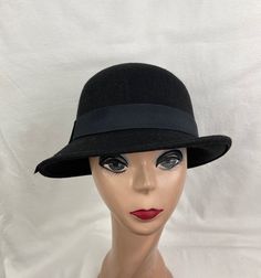 This vintage-inspired Black 1920s style wool felt cloche hat has a slanted downturned brim that is 2 inches and a black grosgrain ribbon band. The material is wool felt blended with acrylic fabric and the hat is lightweight and comfortable to wear. The inside band has an elastic sizing cord to adjust to your head size and will fit up to 22.5-inch heads. Retro Winter Fedora With Curved Brim, Retro Curved Brim Felt Hat For Winter, Retro Fitted Brimmed Felt Hat, Fitted Fur Felt Cloche Hat With Flat Brim, Retro Adjustable Felt Hat For Formal Occasions, Adjustable Retro Felt Hat For Formal Occasions, Retro Top Hat With Curved Brim For Winter, Retro Curved Brim Top Hat For Winter, Fitted Cloche Hat With Short Brim